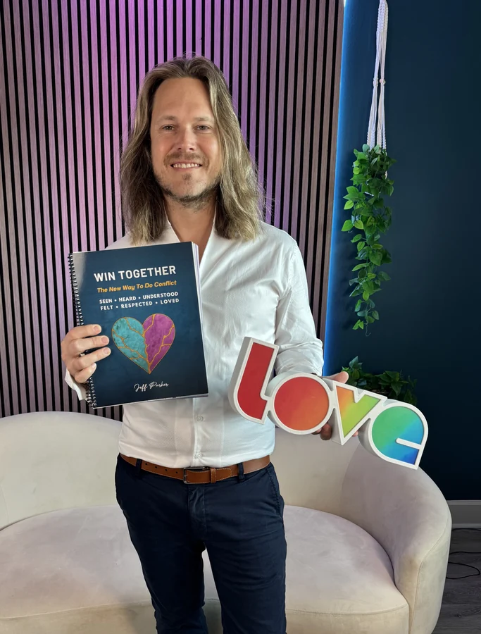 Jeff Parker Love holding Win Together beside a LOVE sign