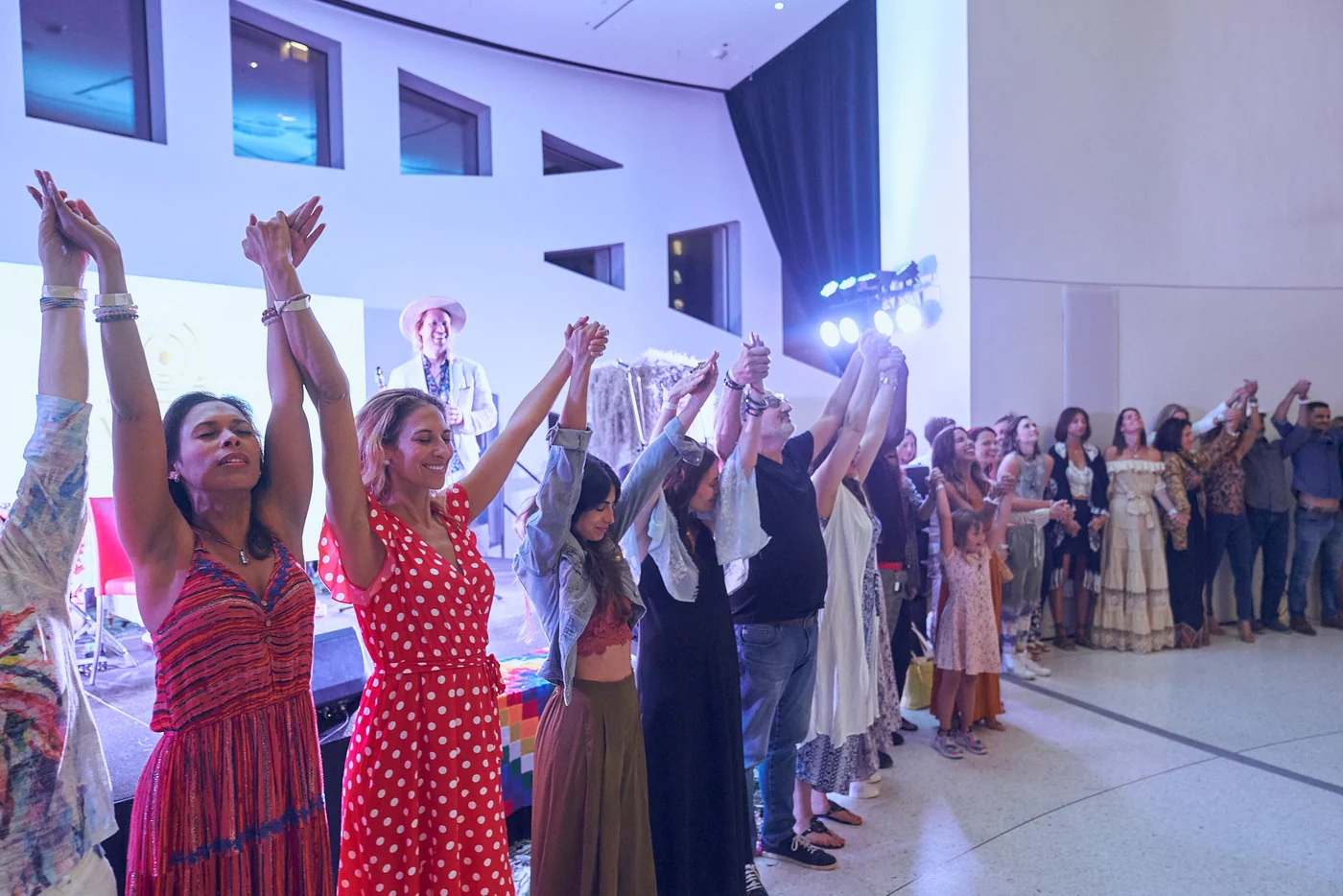 A full room on its feet, hands joined