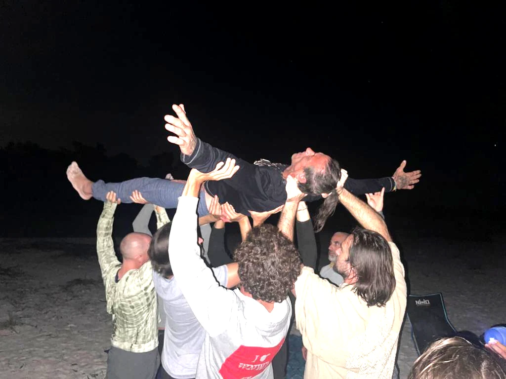 A group of men holding one man above their heads