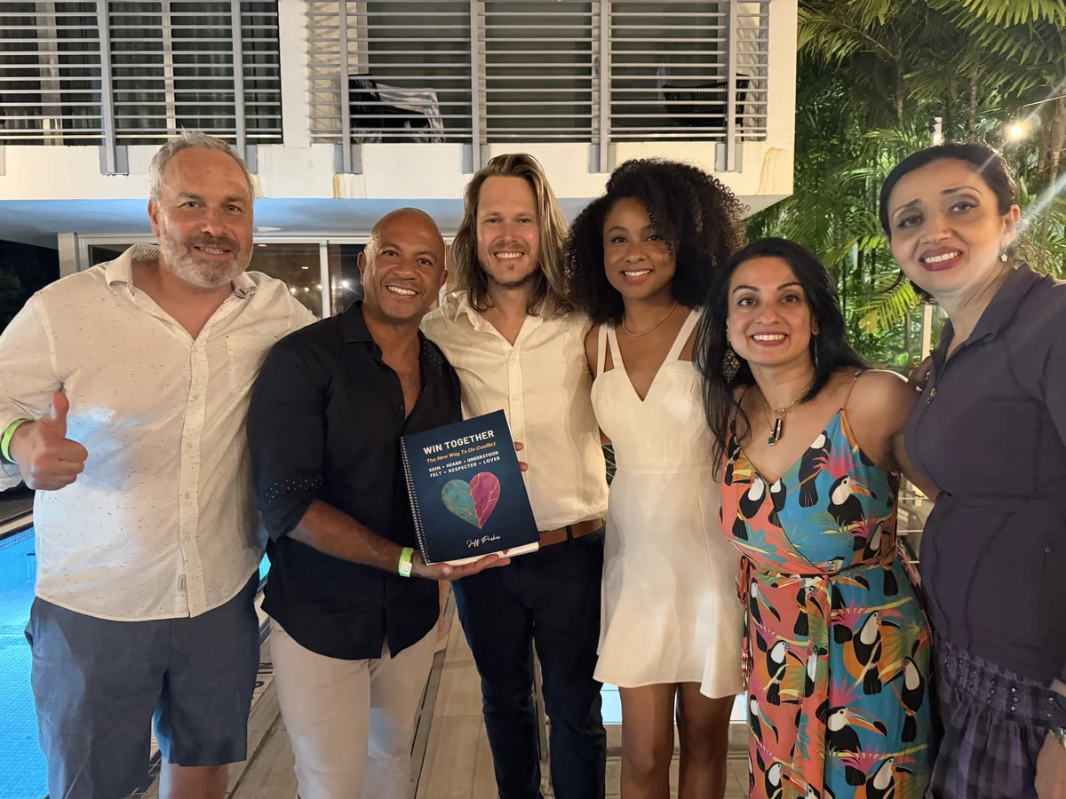 A group holding copies of Win Together at the launch