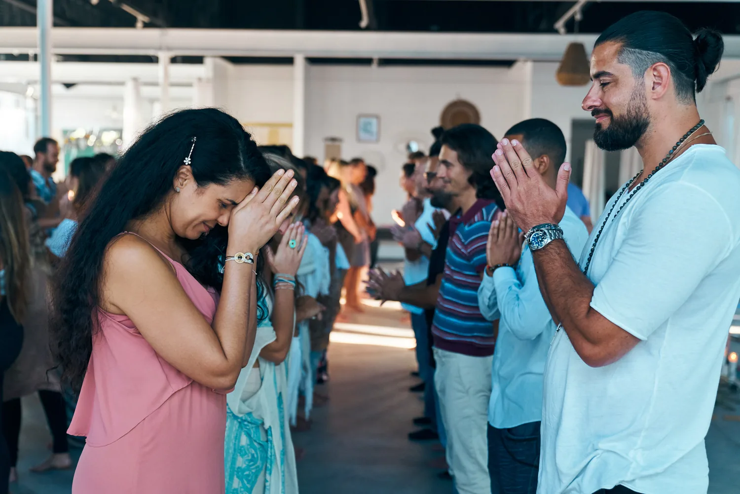 Two rows of people bowing to each other, hands at their hearts